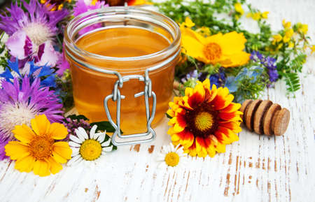Honey and wild flowers on a wooden backgroundの写真素材