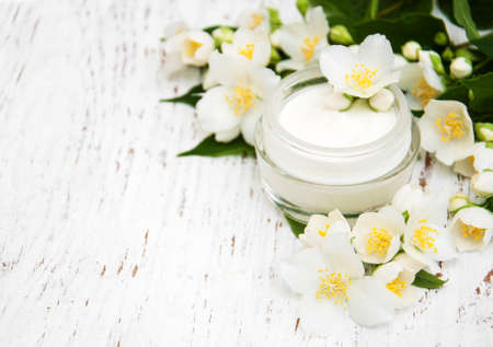 face and body cream moisturizers with jasmine flowers on white wooden backgroundの写真素材