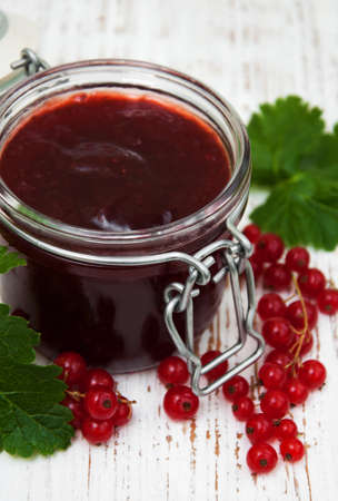 Redcurrants jam with fresh berries on a wooden backgroundの写真素材