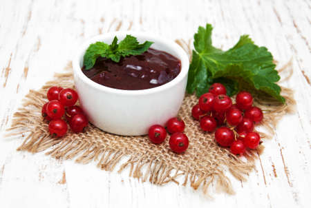 Redcurrants jam with fresh berries on a wooden backgroundの写真素材
