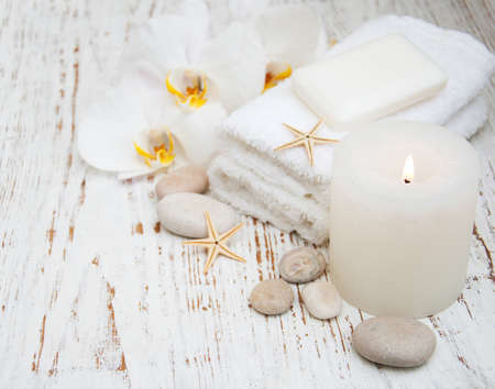 Candle, orchids and towels on a wooden backgroundの写真素材