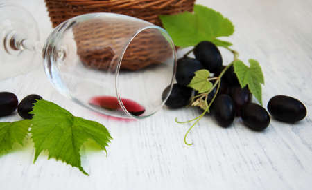 Glass with wine lying on a old wooden backgroundの写真素材