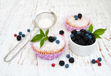 muffins with berries on a old wooden backgroundの写真素材