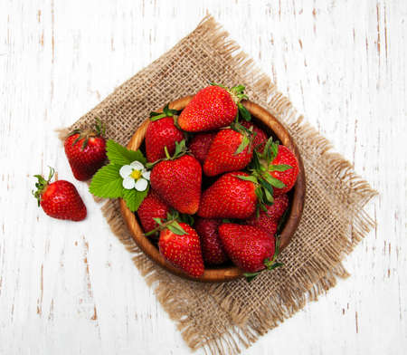 Bowl with strawberries on a old wooden backgroundの写真素材