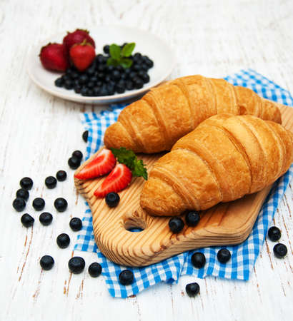 Fresh berries and croissant on a wooden backgroundの写真素材