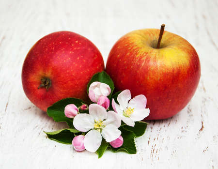 apples and apple tree blossoms on a wooden backgroundの写真素材