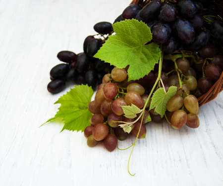 basket with grapes bunch on a old wooden backgroundの写真素材