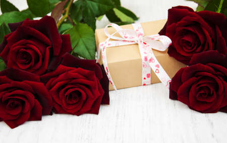 Red roses and gift box on a wooden backgroundの写真素材