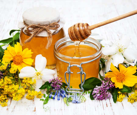 Honey and wild flowers on a wooden backgroundの写真素材