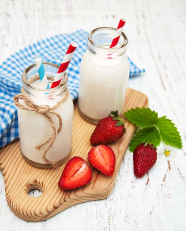 Milk and strawberries on a wooden backgroundの写真素材