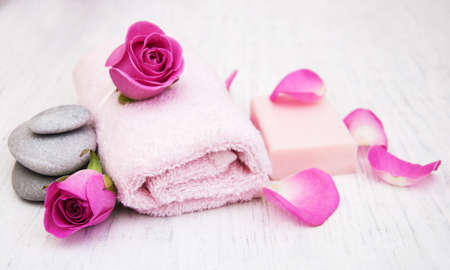 Bath towels and soap with pink roses on a old wooden backgroundの写真素材