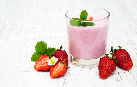 Strawberry yogurt with fresh strawberries on a wooden backgroundの写真素材