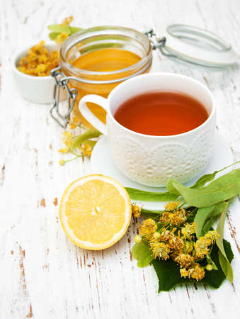 cup of herbal tea with linden flowers on a old wooden backgroundの写真素材