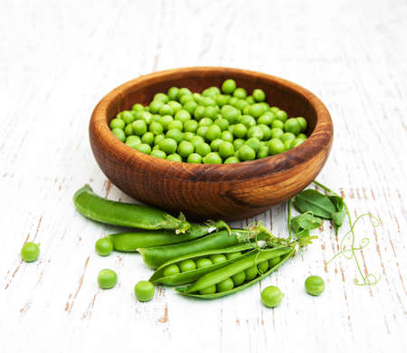Bowl with fresh peas on a wooden backgroundの写真素材