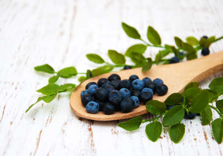 Spoon with Blueberries on a old wooden backgroundの写真素材