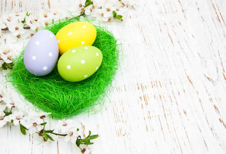 Easter eggs and cherries blossom on a old wooden background
