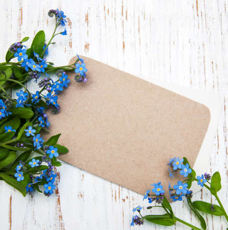 Forget-me-nots flowers with card  on a wooden background
