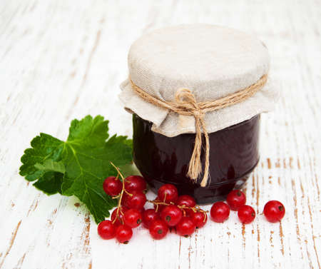 Redcurrants jam with fresh berries on a wooden backgroundの写真素材