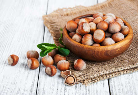 Bowl with hazelnuts on a old wooden tableの写真素材