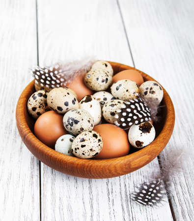 bowl with fresh  eggs on a old wooden tableの写真素材