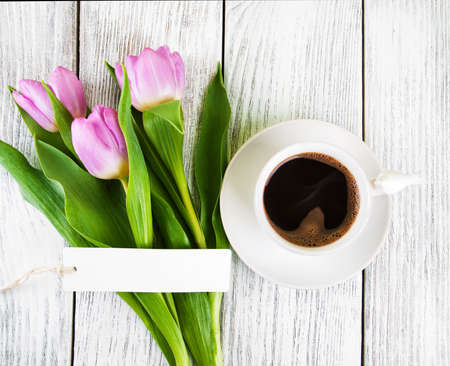 tulips bouquet blank greeting card and coffee cup on a wooden tableの写真素材