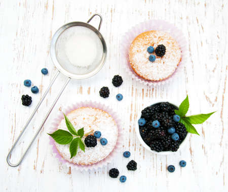 muffins with berries on a old wooden backgroundの写真素材