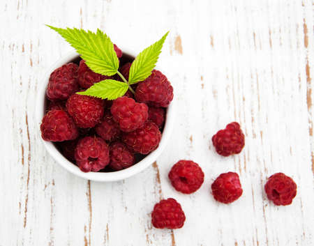 Bowl with raspberries on a old wooden backgroundの写真素材