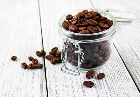 Jar with coffee  beans on a old wooden tableの写真素材