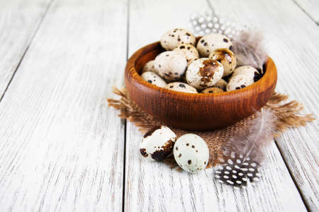 bowl with fresh quail eggs on a old wooden tableの写真素材