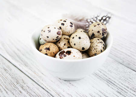 bowl with fresh quail eggs on a old wooden tableの写真素材