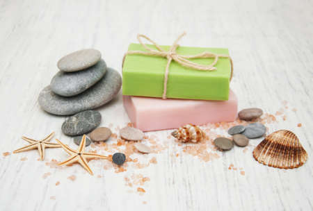 Spa concept with soap and massage stones on a old wooden backgroundの写真素材