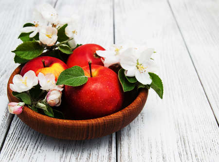 apples and apple tree blossoms on a wooden backgroundの写真素材