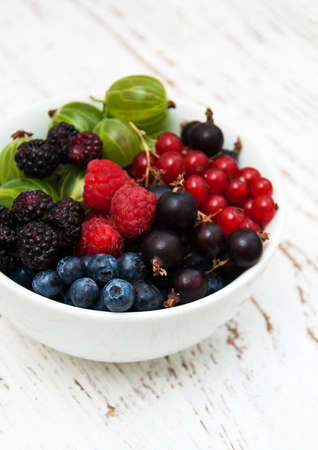 bowl with berries on a old wooden backgroundの写真素材