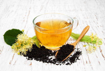 cup of herbal tea with linden flowers on a old wooden backgroundの写真素材