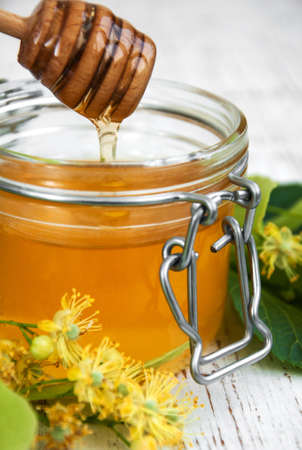 Jar with honey and linden flowers on a wooden backgroundの写真素材