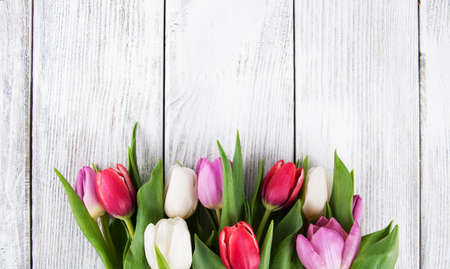 bouquet of fresh spring tulips -  flowers floral border on a wooden backgroundの写真素材