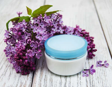 pot of moisturizing cream with lilac flowersの写真素材