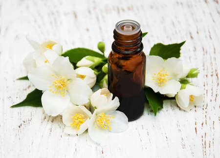Massage oil with jasmine flowers on a wooden backgroundの写真素材