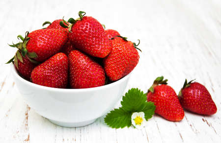 Bowl with strawberries on a old wooden backgroundの写真素材