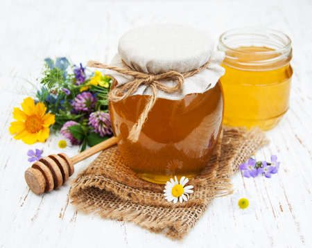 Honey and wild flowers on a wooden backgroundの写真素材