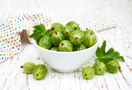 gooseberries with leaves on a old wooden backgroundの写真素材