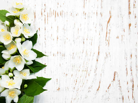 Border with jasmine flowers on a wooden backgroundの写真素材