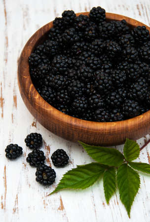 Bowl with Blackberries on a old wooden backgroundの写真素材