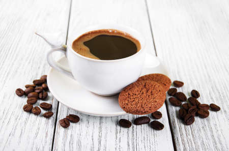 cup of coffee and cookies on a old wooden tableの写真素材