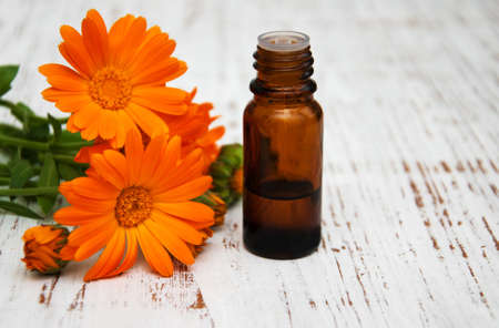 calendula flowers  and massage oil on a wooden backgroundの写真素材