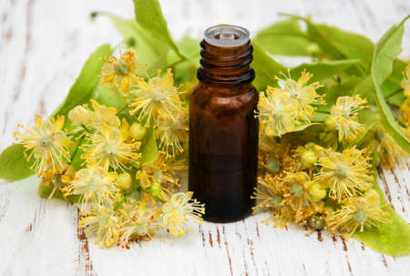 bottle of essential linden oil and yellow lime flowersの写真素材