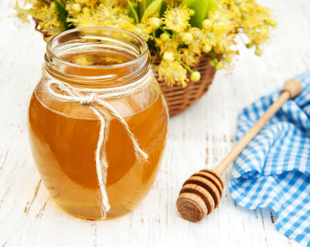 Jar with honey and linden flowers on a wooden backgroundの写真素材
