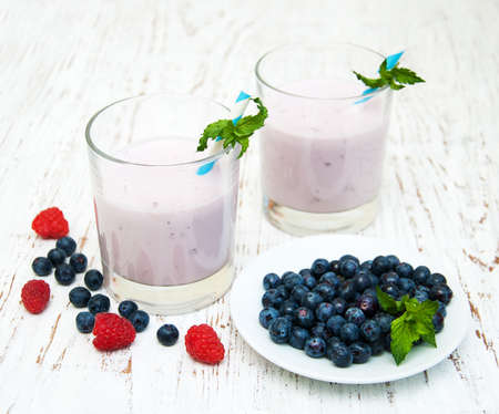 fresh fruit yogurt with blueberries on a wooden backgroundの写真素材