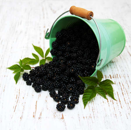 Fresh Blackberries with green leaves  on a wooden  backgroundの写真素材