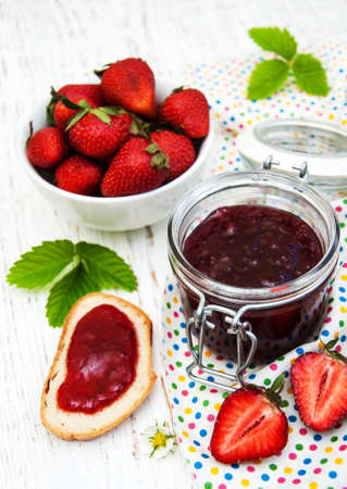 Strawberry jam and fresh strawberries on a wooden backgroundの写真素材